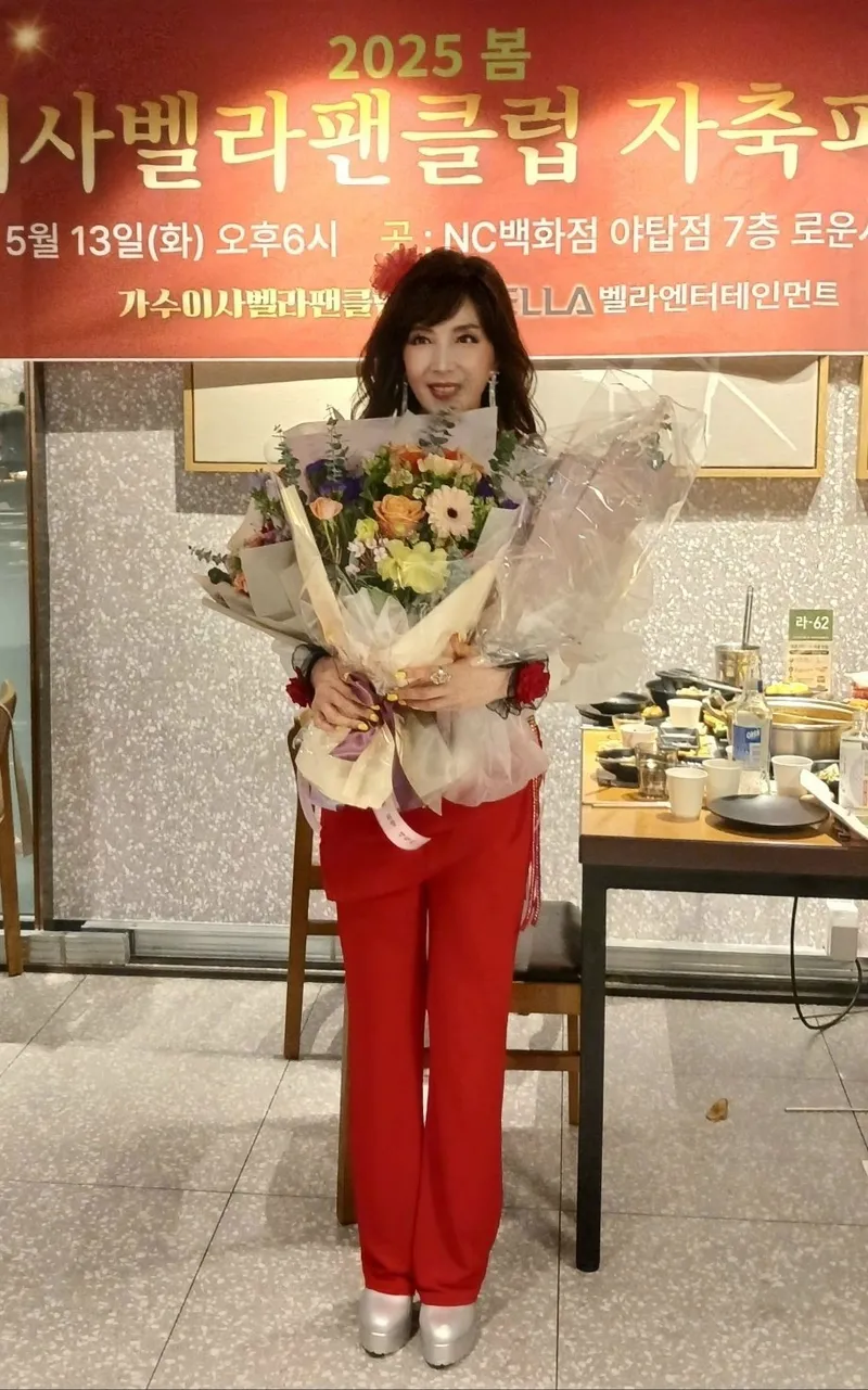 가수 이사벨라가 축하 꽃다발을 받고 포즈를 취하고 있다.