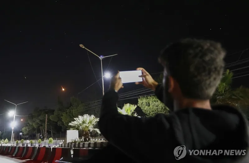 시리아의 한 남성이 다마스쿠스 상공을 지나는 이란 미사일을 촬영하고 있다 / 연합뉴스